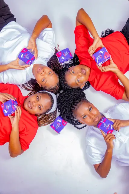 Her Essence ambassadors lying in a circle holding sanitary pads