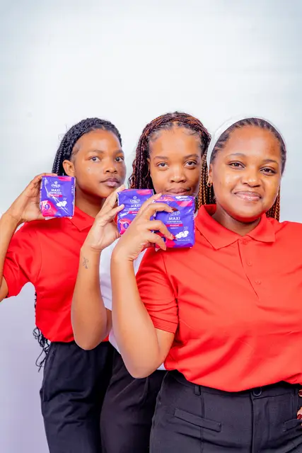 Three young women in red supporting the Her Essence drive