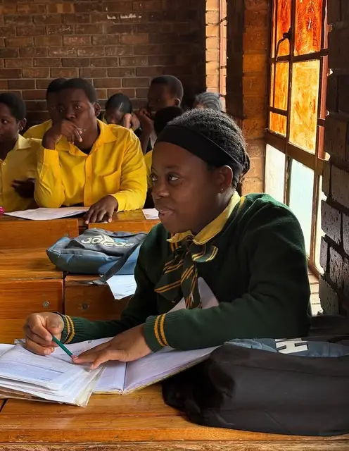A learner focused on her schoolwork in class